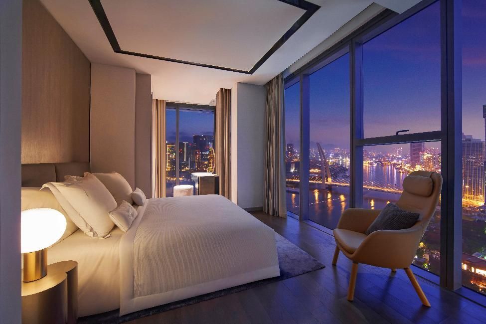 A bedroom with a view of a cityAI-generated content may be incorrect.