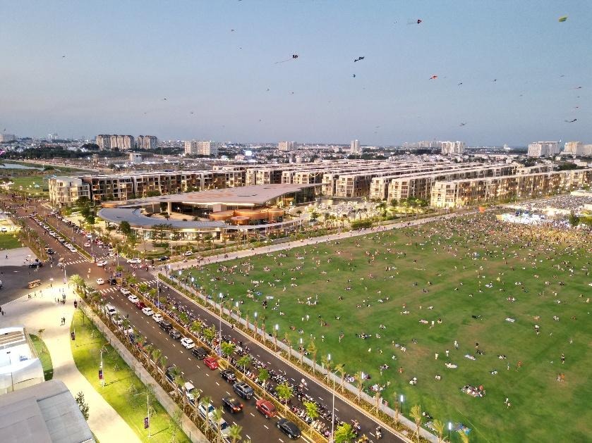 A large green field with many people and buildings
AI-generated content may be incorrect.