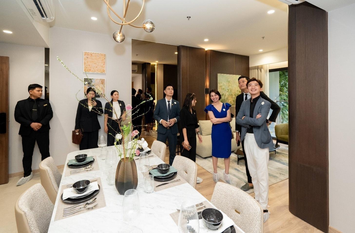 A group of people standing around a tableAI-generated content may be incorrect.