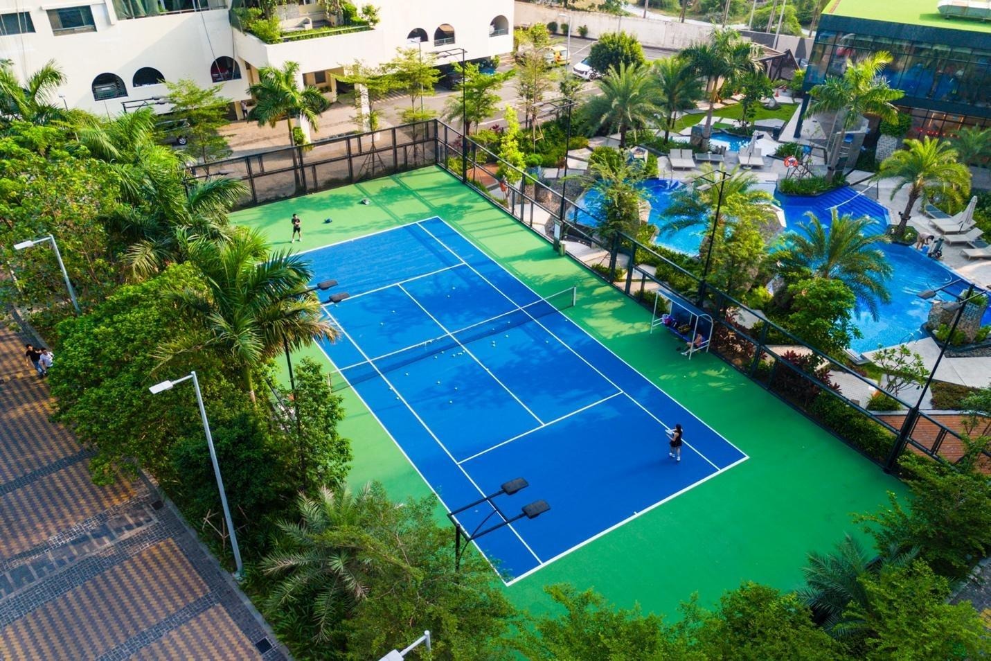 A tennis court with people playing tennisAI-generated content may be incorrect.